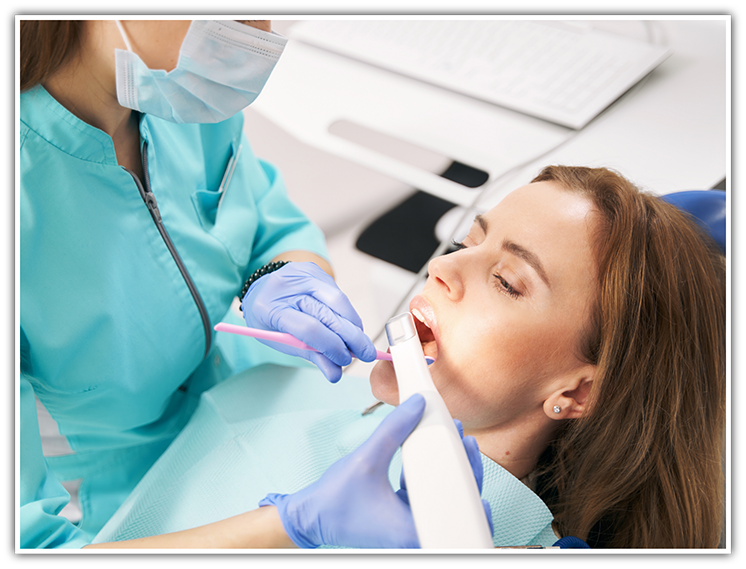 Woman sitting back in dental chair having teeth scanned