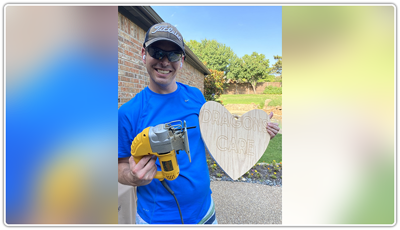 Man holding heart made out of wood with power saw