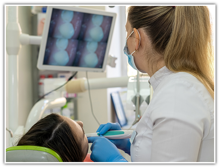 Female dentist looking at teeth with intraoral camera