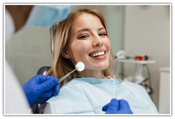 Female patient in dental chair smiling at dentist