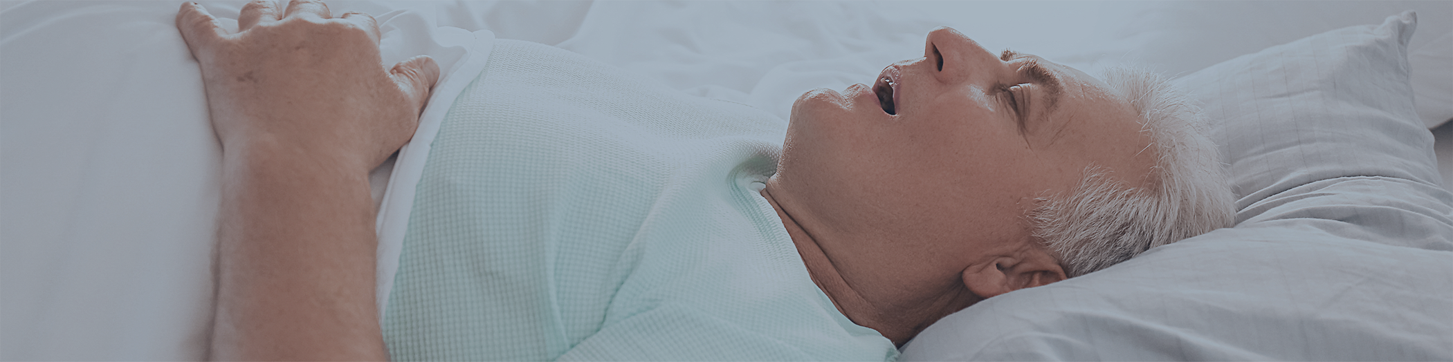 Close-up of man snoring in bed