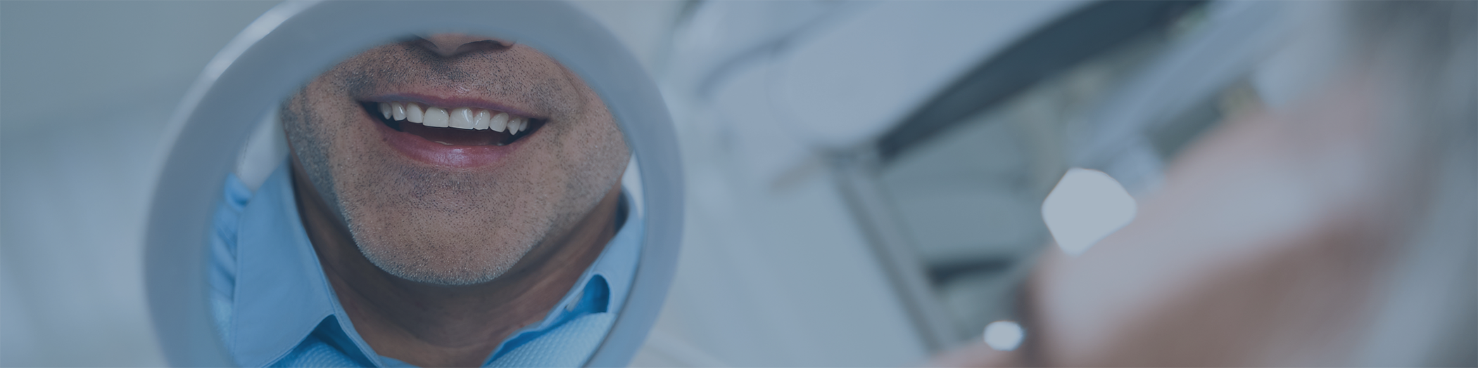 Close-up of man checking his smile in a mirror
