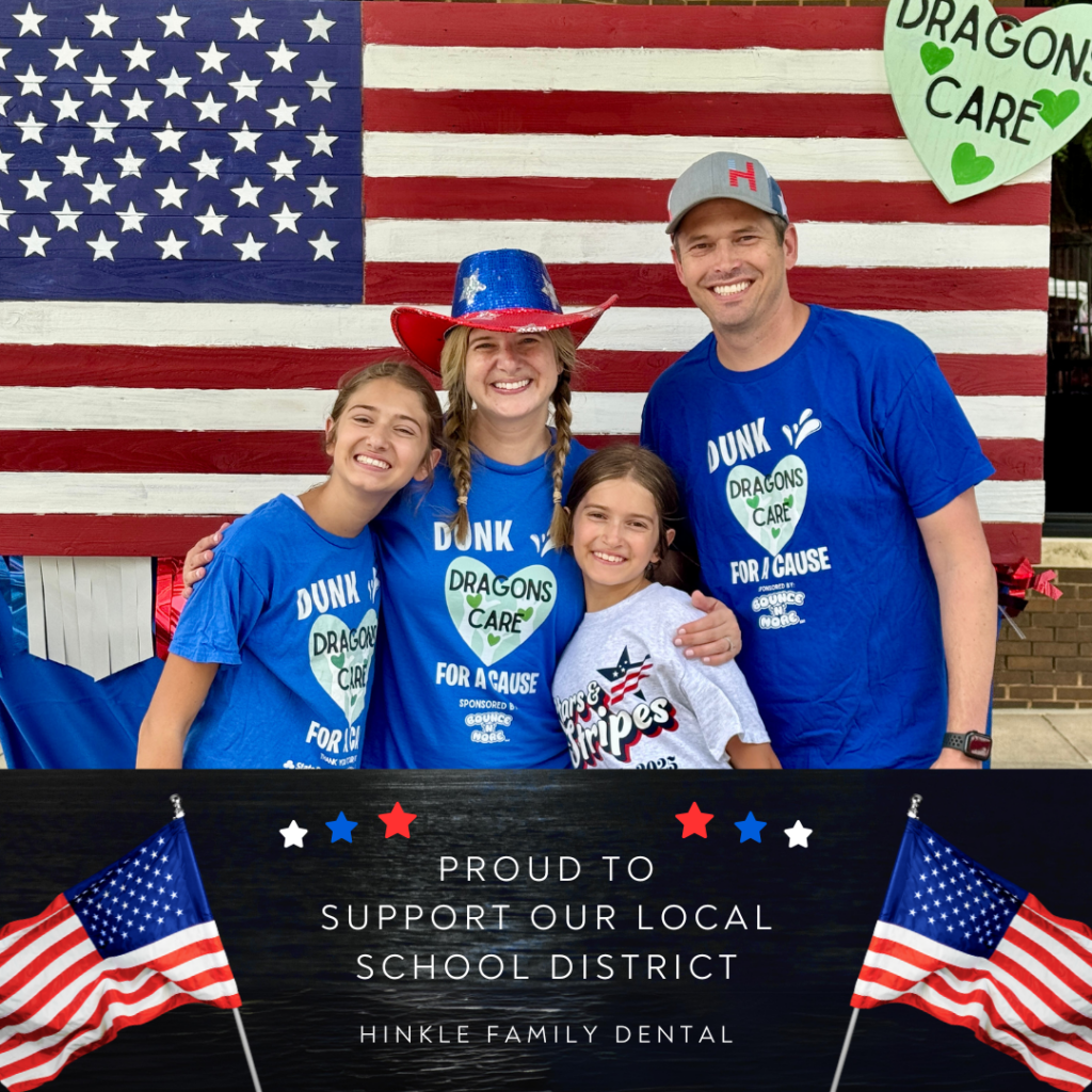 A family stands proudly in front of an American flag, holding a sign that reads Support Our Local School District from Hinkle Family Dental.